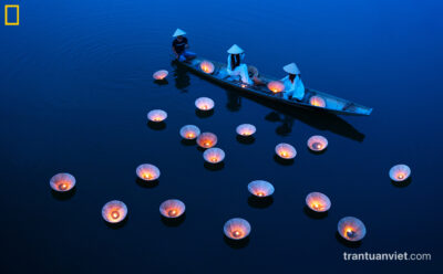 Young women perform the rid of candles lights floating in Hue, Vietnam
